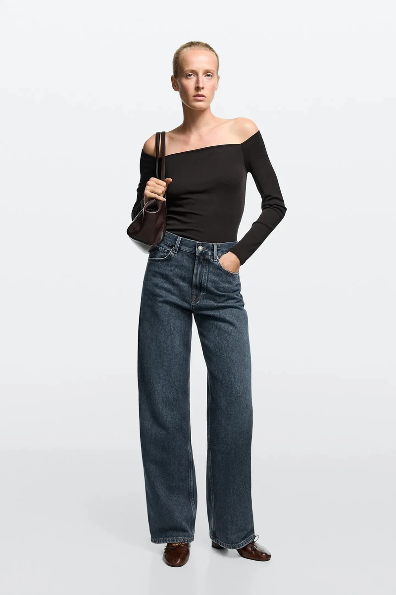 Модель у чорній кофті та джинсах wide leg