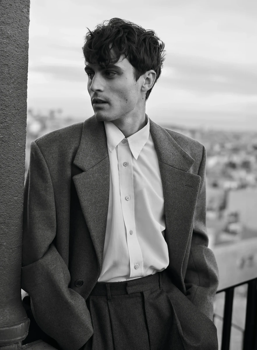 Жульєн у пальто Givenchy замислився про щось на балконі