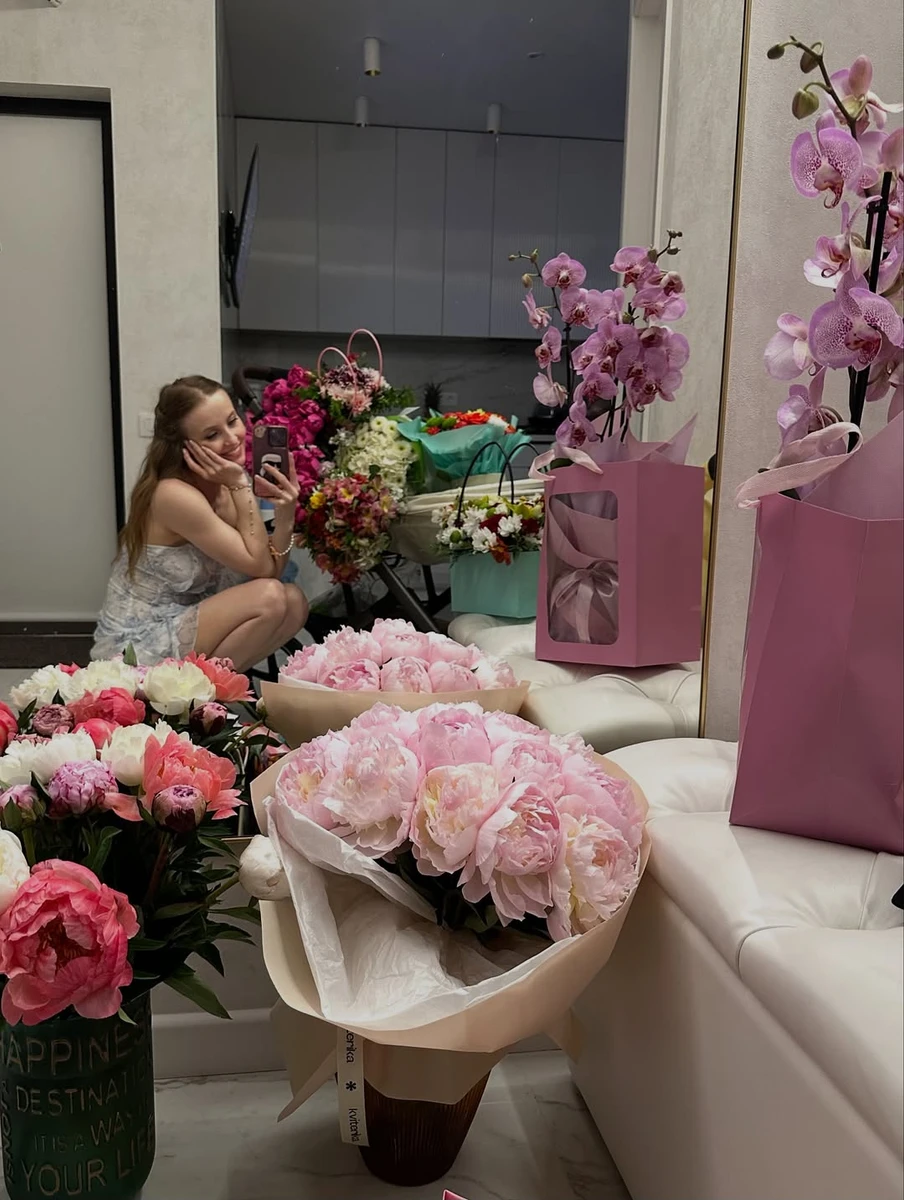 Анна Сагайдачна у мінісукні посиділа біля букетів квітів