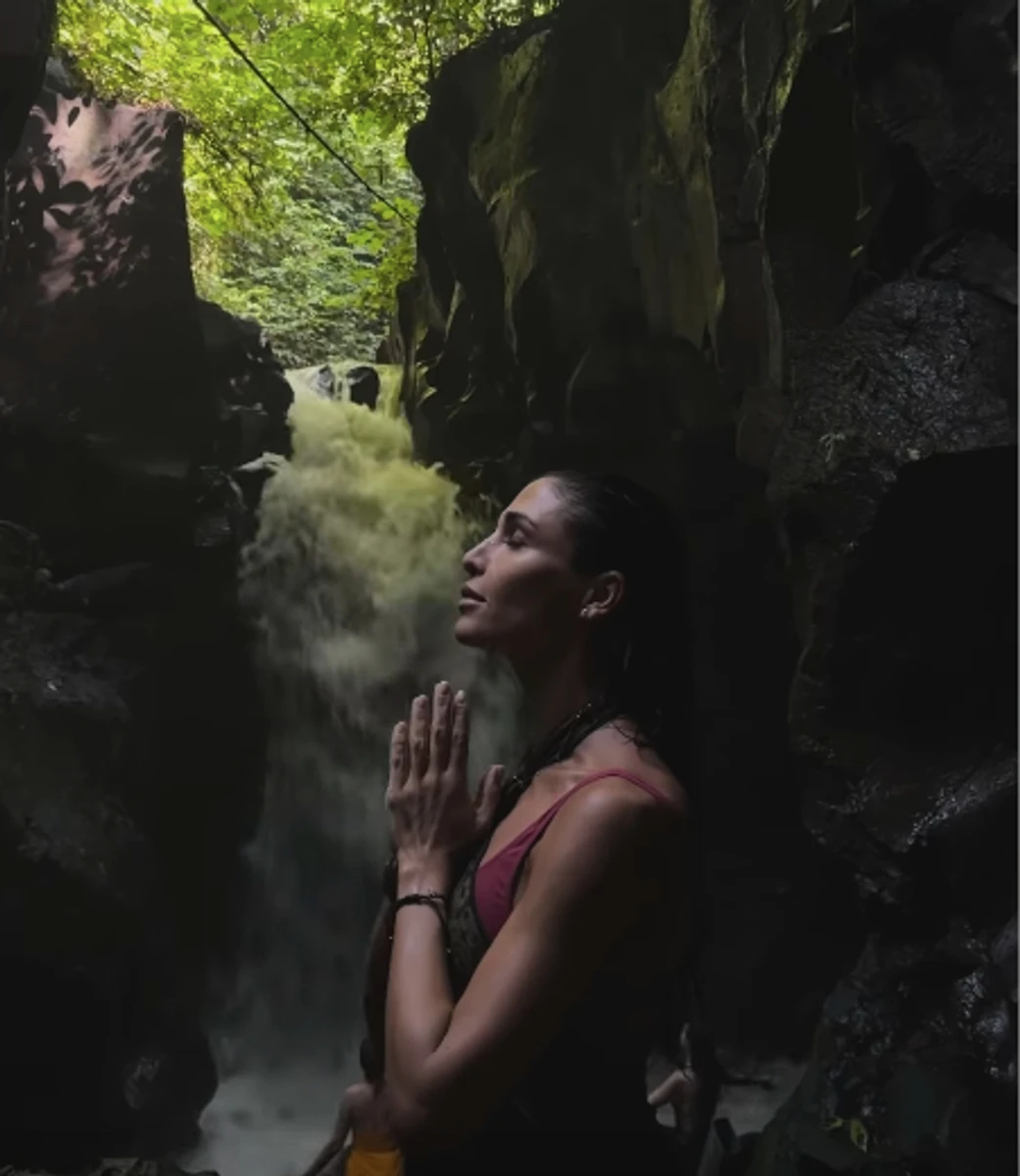 Санта Дімопулос у топі попозувала біля водоспаду