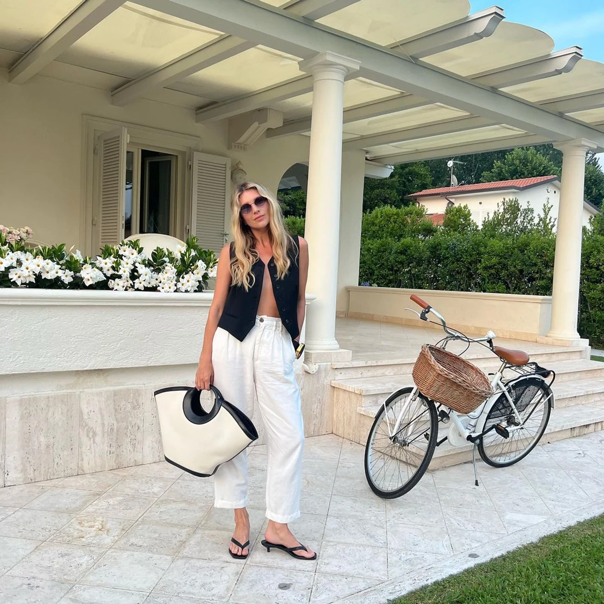 Катерина Сільченко у жилетці та білих штанах