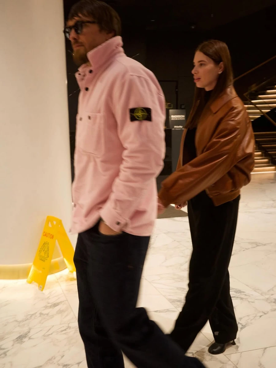 Олександр Усик у рожевій кофті потримав дружину за руку для фото