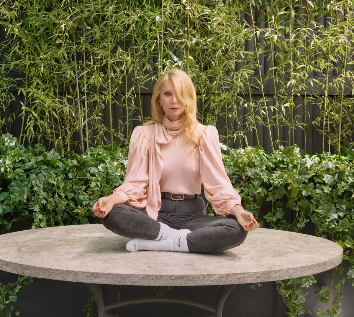 Гвінет Пелтроу у рожевій блузці помедитувала на столі для фото в глянці