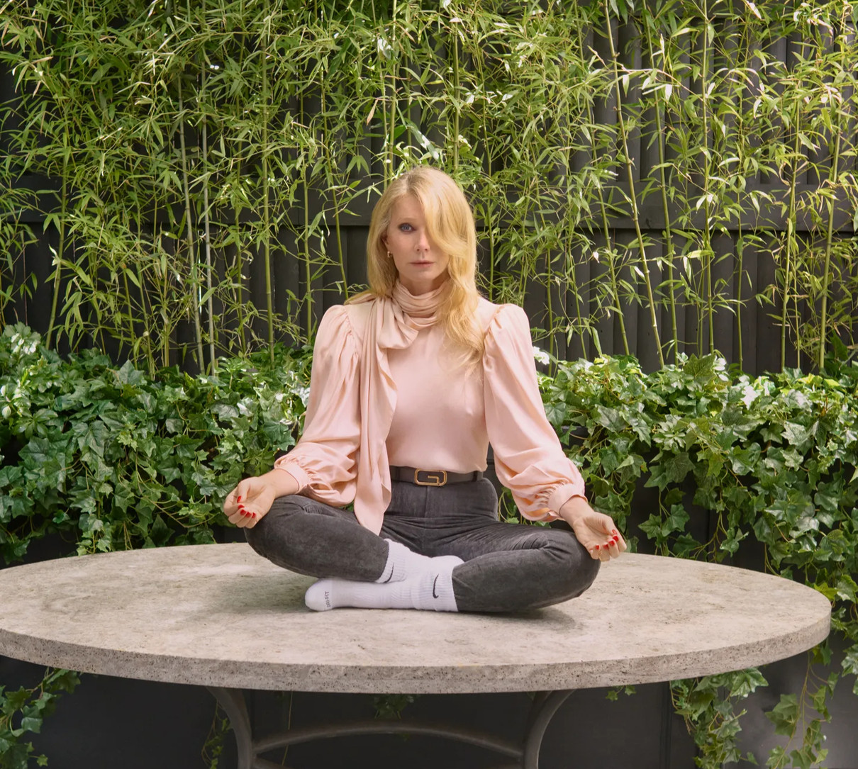 Гвінет Пелтроу у рожевій блузці помедитувала на столі для фото в глянці