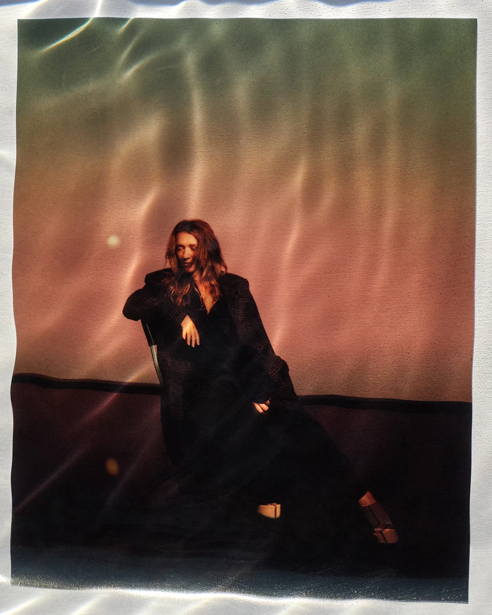 Наталія Могилевська у сукні і пальто попозувала на стільці для журналу